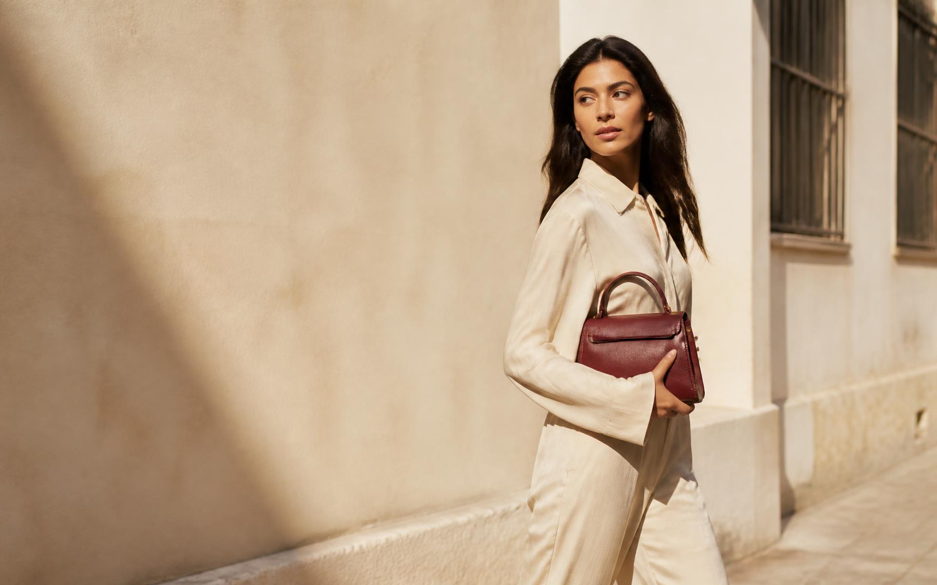 KATISKA editorial campaign — model carrying a burgundy leather handbag